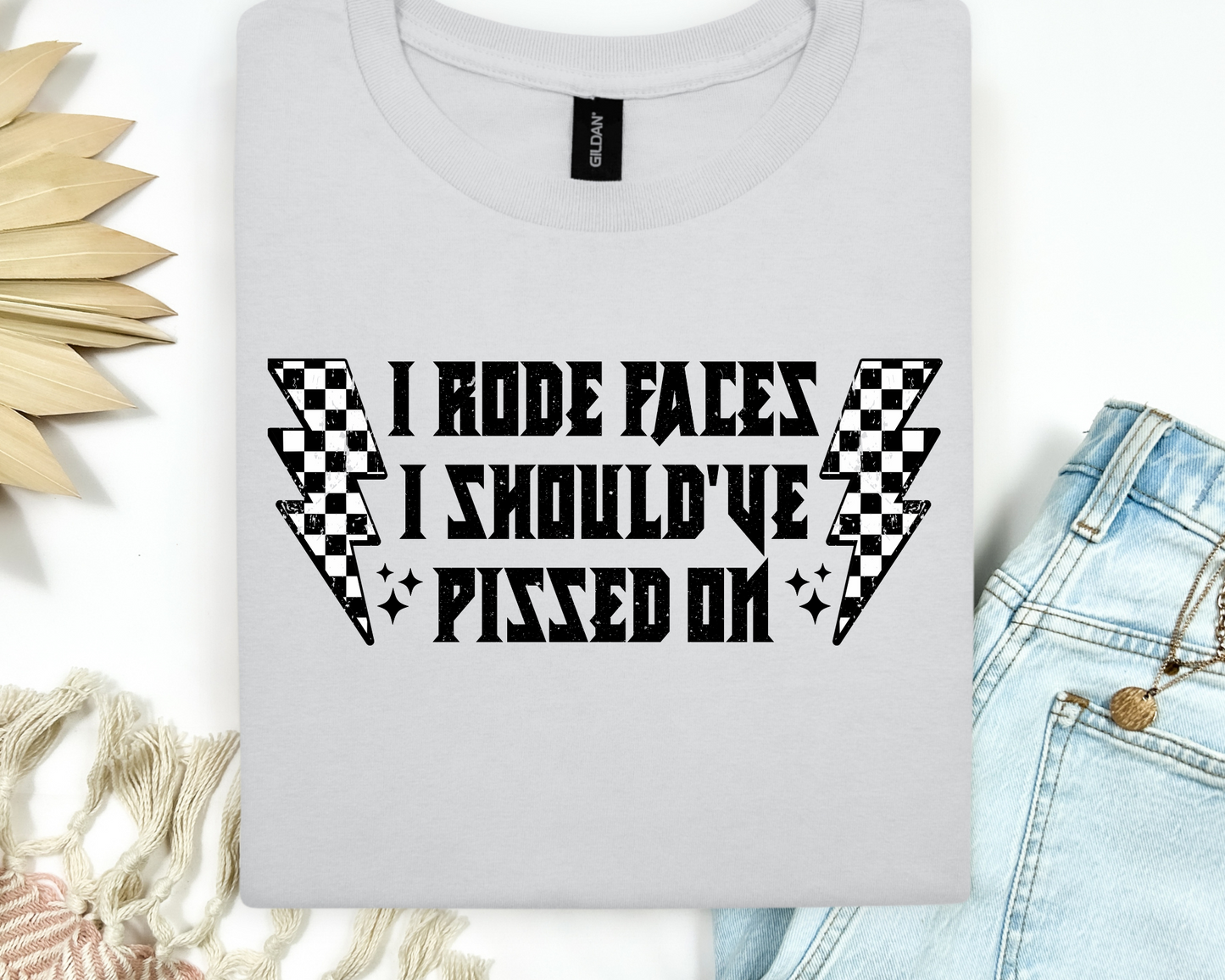 "I Rode Faces I Should've Pissed On" Graphic Tee – Checkered Lightning Bolt Design